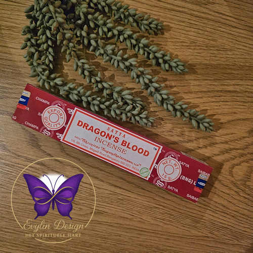 Satya Dragon’s Blood wierookdoosje op houten ondergrond met groene decoratietakjes en het paarse Evylin Design logo