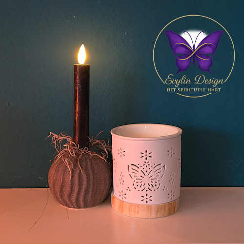 Witte keramische waxbrander met vlinderdesign naast brandende kaars, met Evylin Design logo op achtergrond